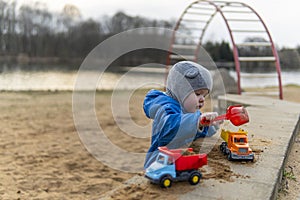 The kid pours sand into the machine