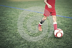 Kid practicing soccer on field