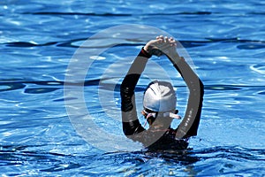 Kid prepares to swim in a swimming pool.