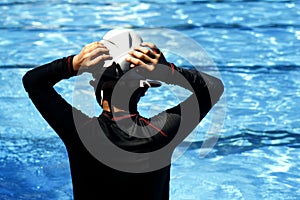 Kid prepares to swim in a swimming pool.