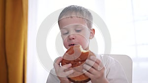 Kid preschool boy eats hamburger a breakfast at recess. Happy family fast food kid dream concept. Child son eating