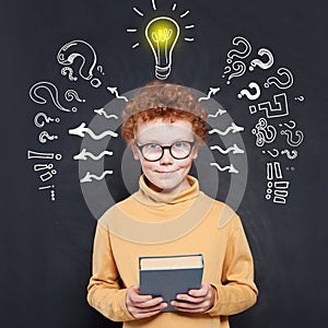 Kid with question marks and lightbulb on blackboard background