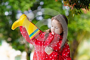 Kid with rain boots. Waterproof wear for children