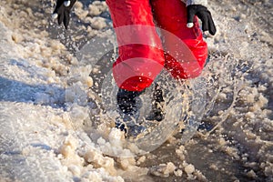 Kid in rainboots jumping in the ice puddle photo