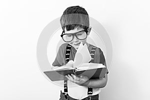 Kid read book, suspender and eyeglasses.