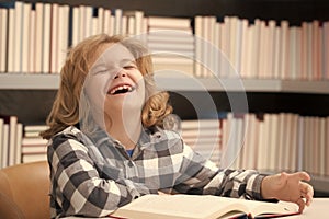 Kid reading a book in a school library. School boy education concept.