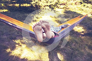 Kid is relaxing and swinging in a hammock