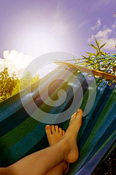 Kid is relaxing and swinging in a hammock