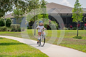 Kid riding bike in a helmet. Child with a childs bike and in protective helmet. Happy kid boy having fun in summer park