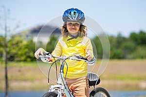 Kid riding bike in a helmet. Child riding bike in protective helmet. Safety kids sports and activity. Happy kid boy