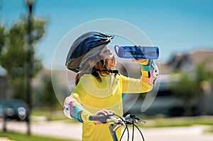 Kid riding bike in a helmet. Child riding bike in protective helmet. Safety kids sports and activity. Happy kid boy