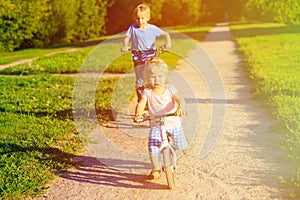 Kid riding bikes in summer park