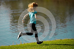 Kid runners run on lawn in park. Child running outdoor. Healthy sport activity for children. Little boy at athletics