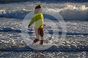 Kid running on beach having fun on summer holidays. Happy kids playing on sea. Children in nature with sea. Happy kids