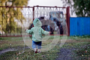 A kid is running on the grass in autumn