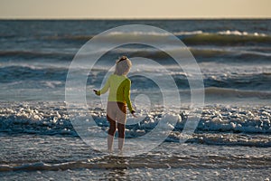 Kid running into sea water during summer holidays. Kid boy running along ocean. Child on summer beach. Child run a race