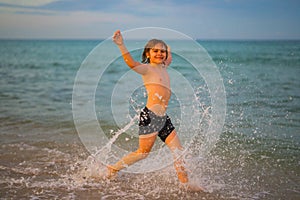 Kid running and splashing in the sea. Summer vacation. Child Running Along the beach. Little kid running at Caribbean
