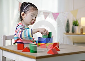 Kid`s creativity, Child little asian girl playing colorful building blocks on the desk in the class room at home, Educational
