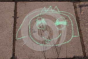 Kid's drawing with pink chalk on the tiles of pavement