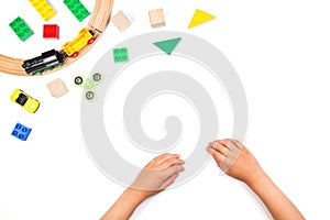 Kid`s hands and colorful toys. Fidget spinner, cars, toy train, bricks and blocks on white background