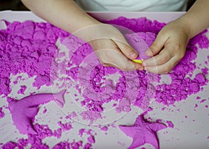 Kid`s hands with kinesthetic sand