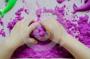 Kid`s hands with kinesthetic sand