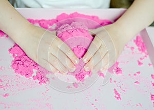 Kid`s hands with kinesthetic sand photo