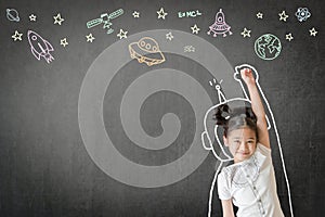 Kid`s learning inspiration in science education with girl child`s imagination doodle on teacher`s chalkboard