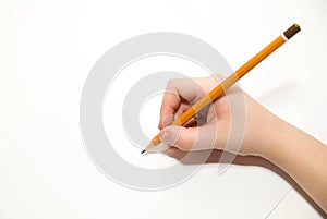 Kid's rigth hand holding a pencil on over white photo