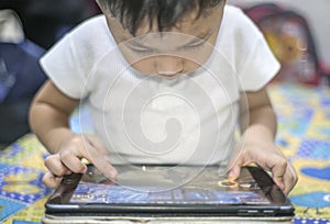 Kid`s using digital touchscreen phone tablet playing online games.