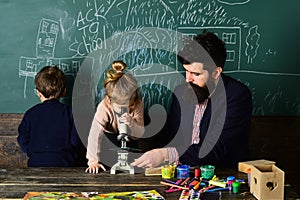 Kid at school room having education activity helped by teacher. Education at the elementary school - pupil writing in