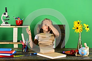 Kid and school supplies on green wall background