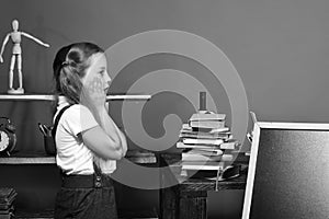 Kid and school supplies on red wall background