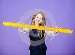 Kid school uniform hold ruler. Pupil cute girl with big ruler. Geometry school subject. Education and school concept