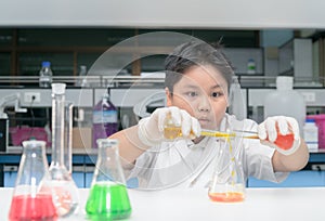 Kid scientist in lab coat making experiment