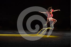 Kid scootering in a night park