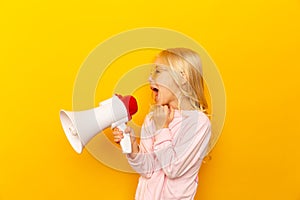 Kid shouting through megaphone. Communication concept. yellow background as copy space for your text