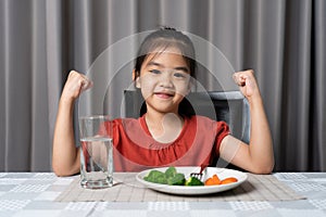 Kid shows strength of eats vegetables and nutritious food