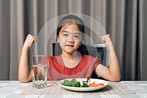 Kid shows strength of eats vegetables and nutritious food