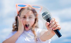 kid sing with mic. selective focus. cheerful event manager. child have fun on party. happy singer with microphone