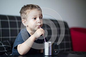 Kid sipping juice while watchnig tv