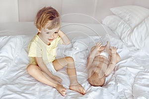 Kid sitting on bed near infant