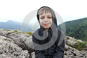 Kid sitting on rock on Lago-Naki plateau in summer