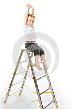 Kid sitting on top of stepladder, hands raise up.