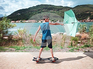 Kid on skateboard with wind and umbrella