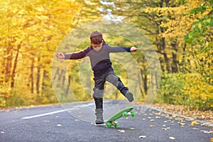 Kid skateboarder doing skateboard tricks in autumn environment