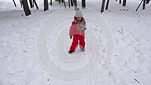 Kid sledding in snow, child playing in winter, little girl sledging in park