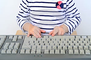 Kid, small child, 2-year-old girl typing with a finger on a computer keyboard, online conference, remote learning concept, early