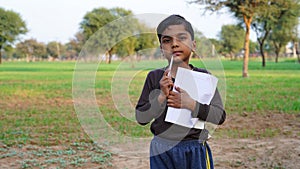 Kid, smile and portrait of student with books for education, study or learning  on a green field background