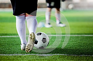 Kid soccer player put white sport shoes jogging and control ball go to other players